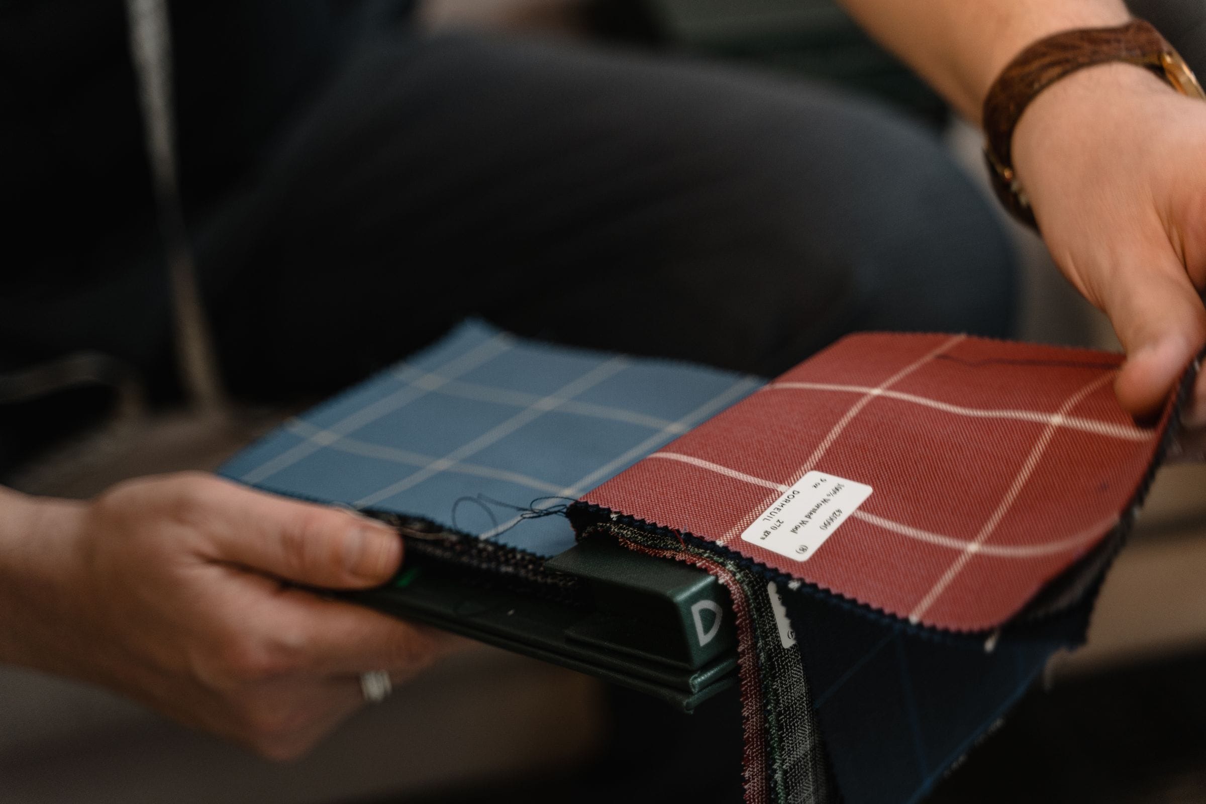 Hand holding a premium Italian textile swatch