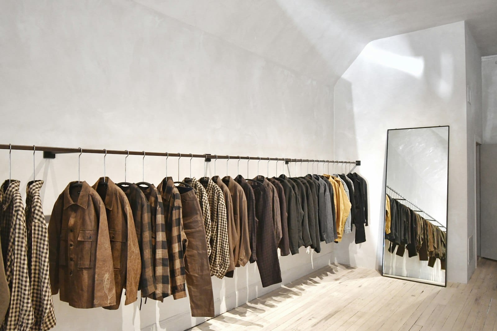 An edited rail of garments in an atelier