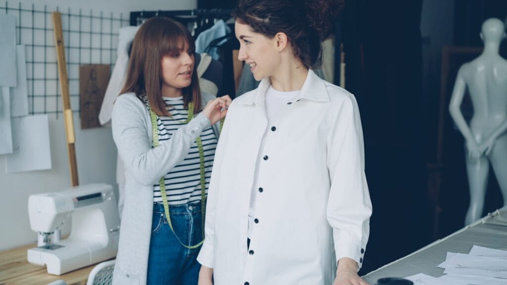 A tailor measuring a client for a custom garment