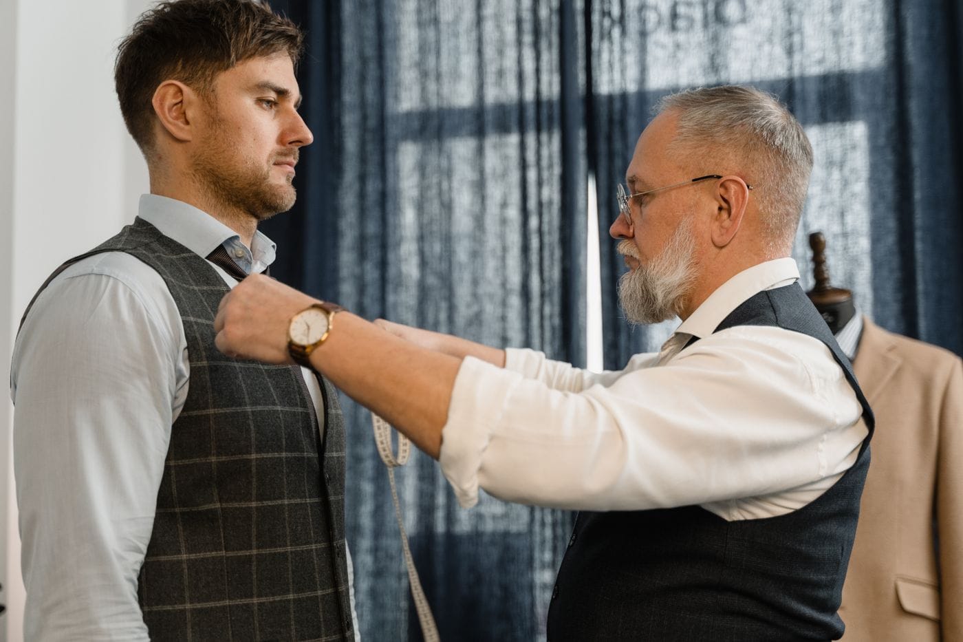 A tailor measuring a client