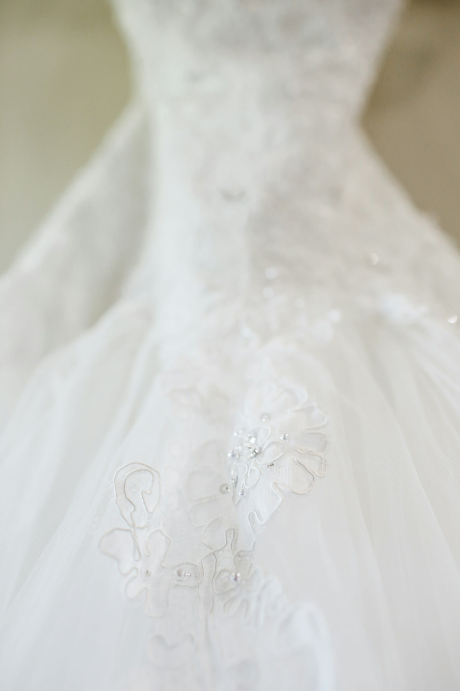 Lace appliqué and beadwork on a bridal gown, hand finished