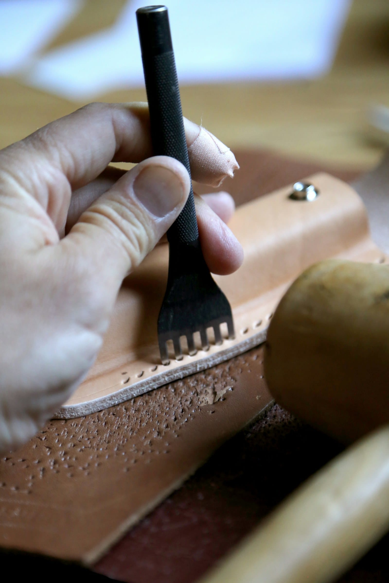 Pricking iron marking stitch holes on vegetable tanned leather