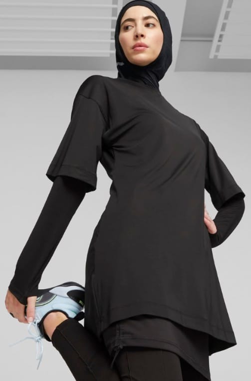 Modest sportswear tunic with a hip clearing hem over a long sleeve layer and leggings
